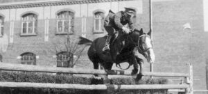 Adam Królikiewicz skacze konno przez przeszkodę w Centrum Wyszkolenia Kawalerii w Grudziądzu